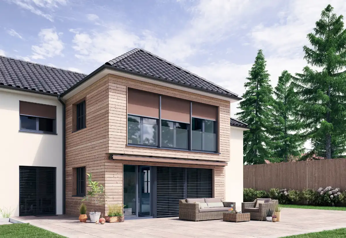 Stilvolles zweistöckiges Haus mit Fenstermarkisen Modernes zweistöckiges Haus mit Holzfassade und Terrassenmöbeln